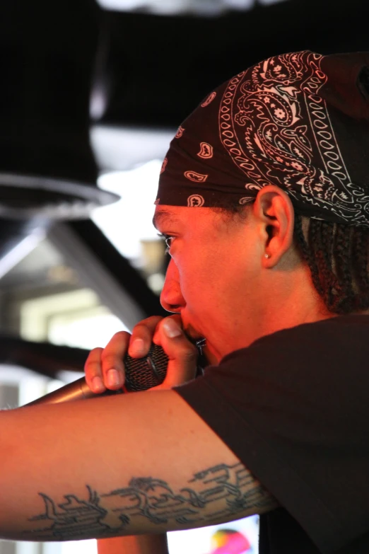 a man talking on a cell phone while wearing a bandana