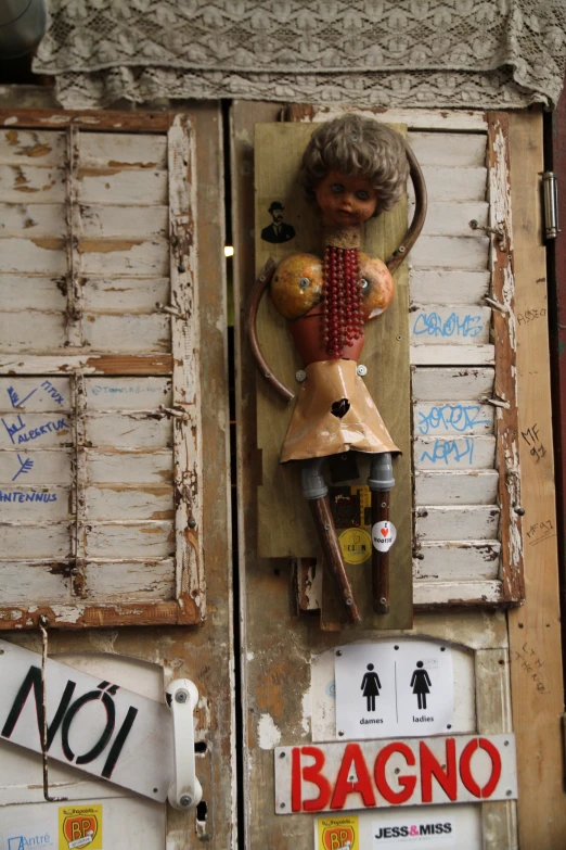 an antique doll of an old woman hanging on a door