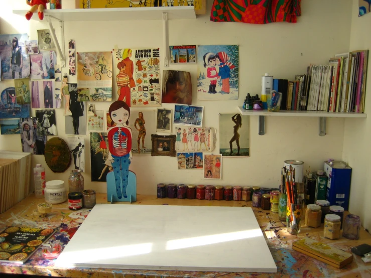 a studio space with various kinds of artwork on the walls