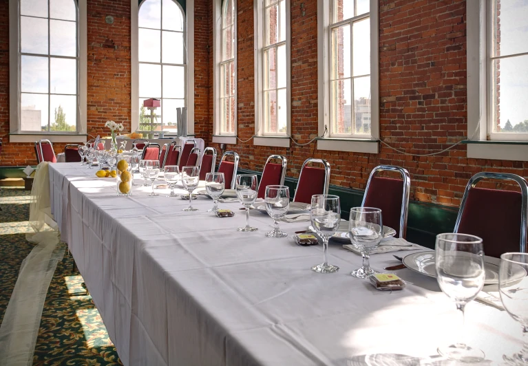 long table laid out with wine glasses and plates for formal dinner