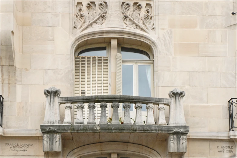 the balcony has an iron fence and wooden slats