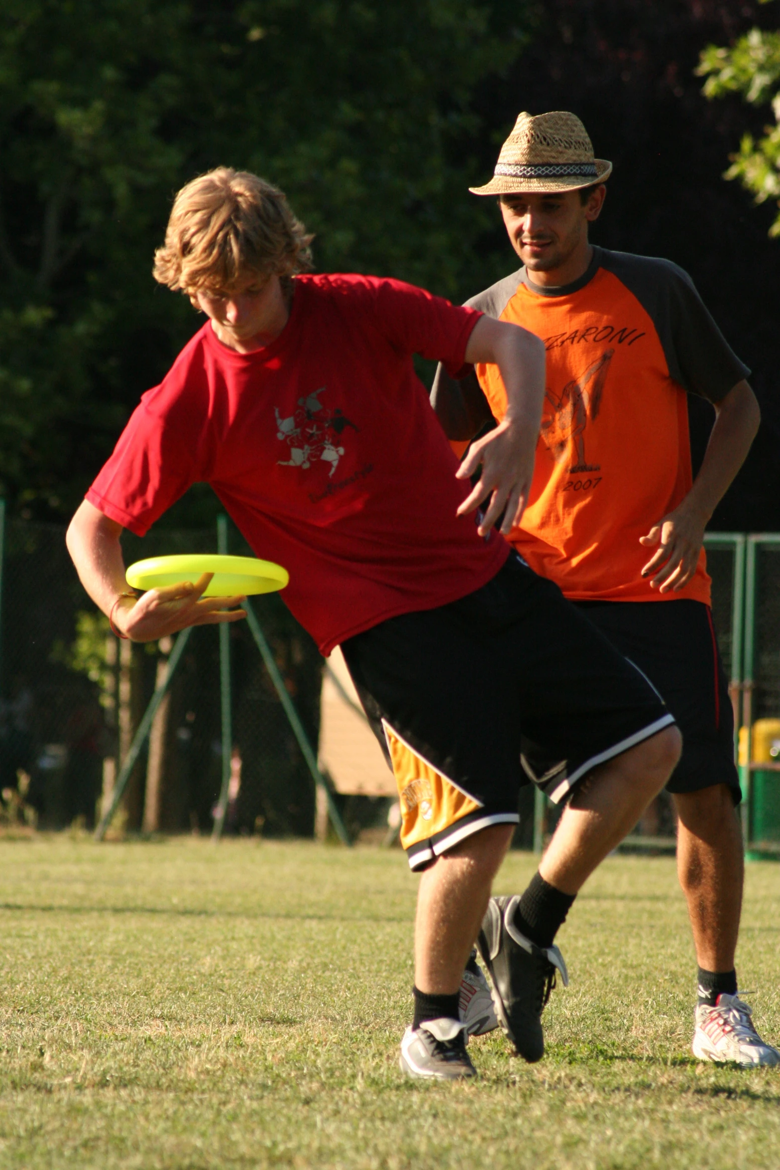 two men are throwing a frisbee on a field