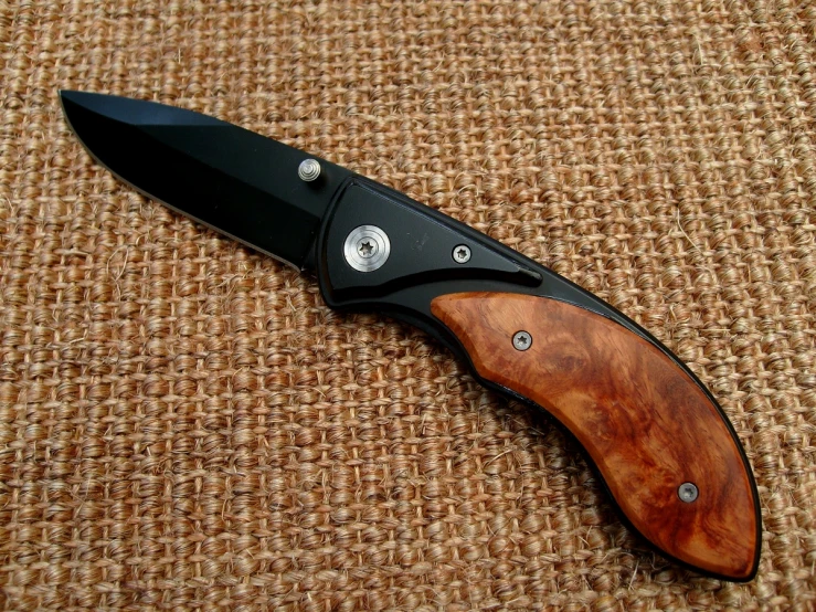 a black and brown knife on top of brown fabric