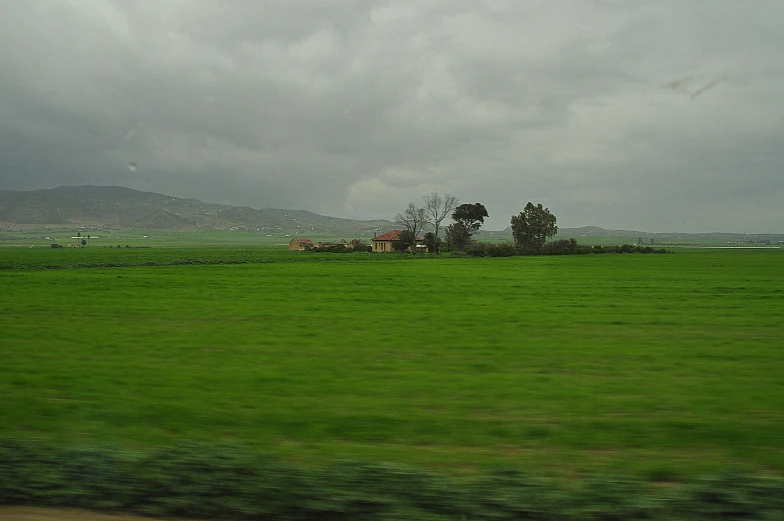 there are many buildings near a field and mountains