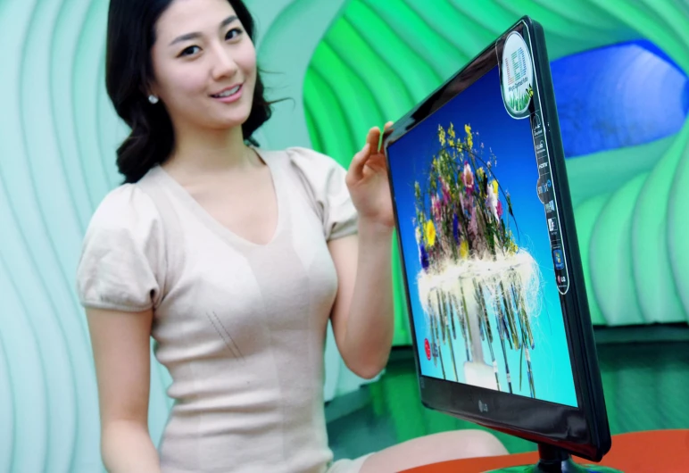 a woman sitting on the floor, showing a picture to the camera