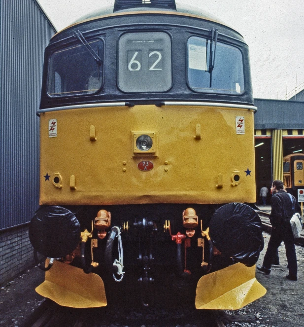 two men in black hats standing by an old train