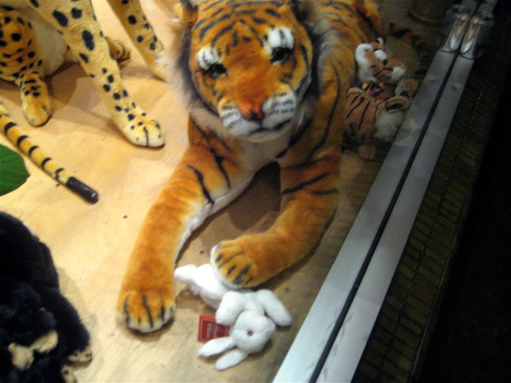 stuffed tigers on the floor and in a store window