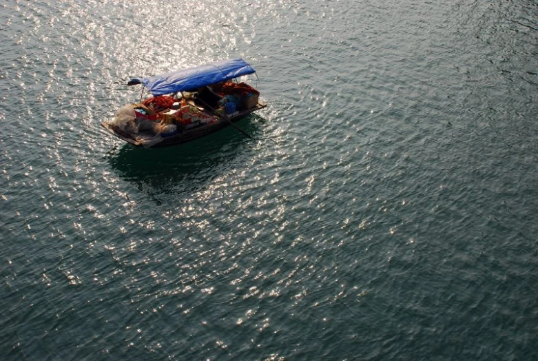 small boat with umbrella in ocean near pier