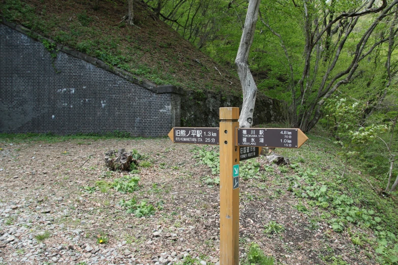 a wooden sign sitting on top of a dirt road