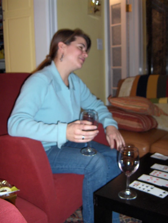 a women who is sitting on a couch with wine