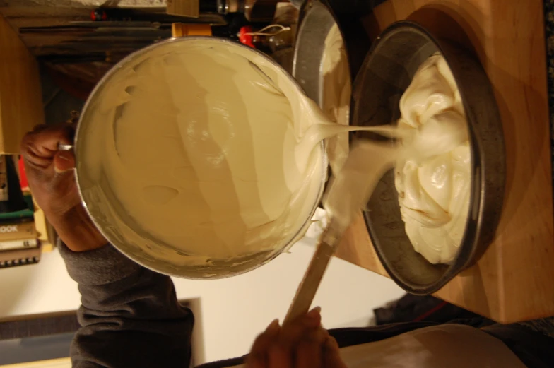 there is cream being poured into a pan
