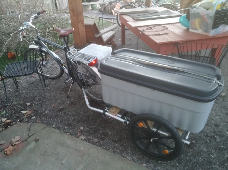 a bike with a cooler on the back in front of it