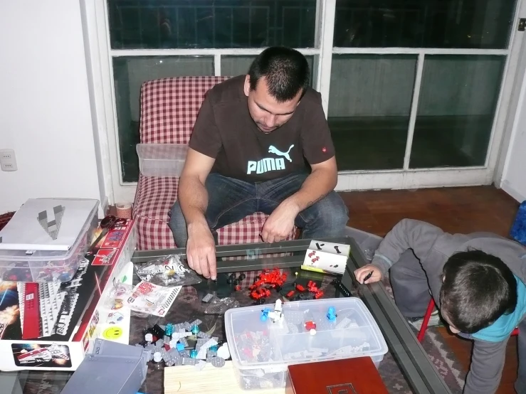 a man sitting on top of a couch next to a little boy