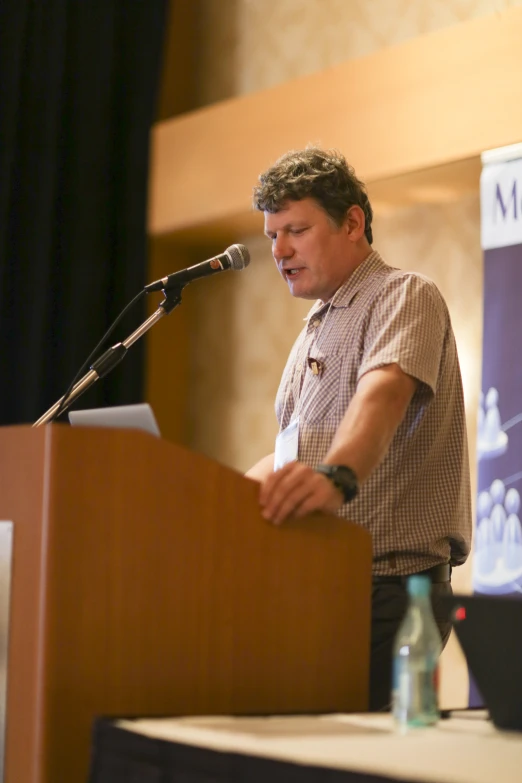 a man standing at a podium with a microphone