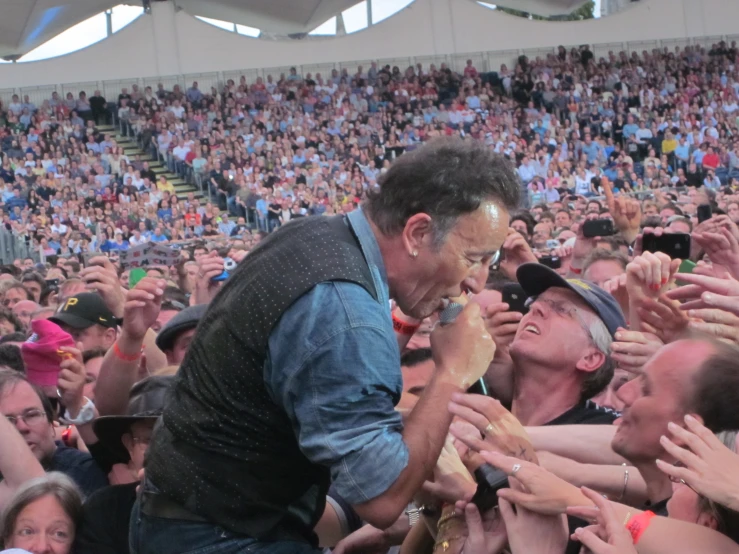 a crowd of people with their hands up to a man