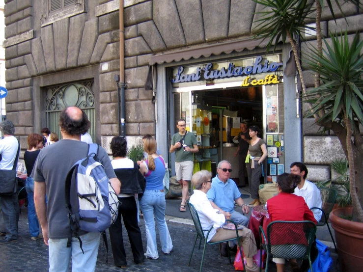 people are lined up outside in front of a restaurant