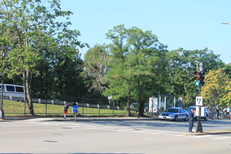 people crossing the road at an intersection in the day