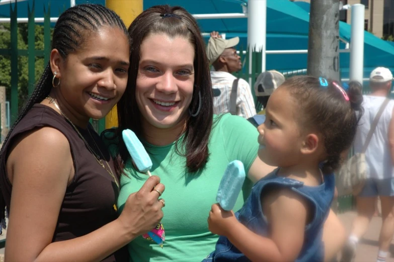 two women and a boy are smiling and holding tooth brushes