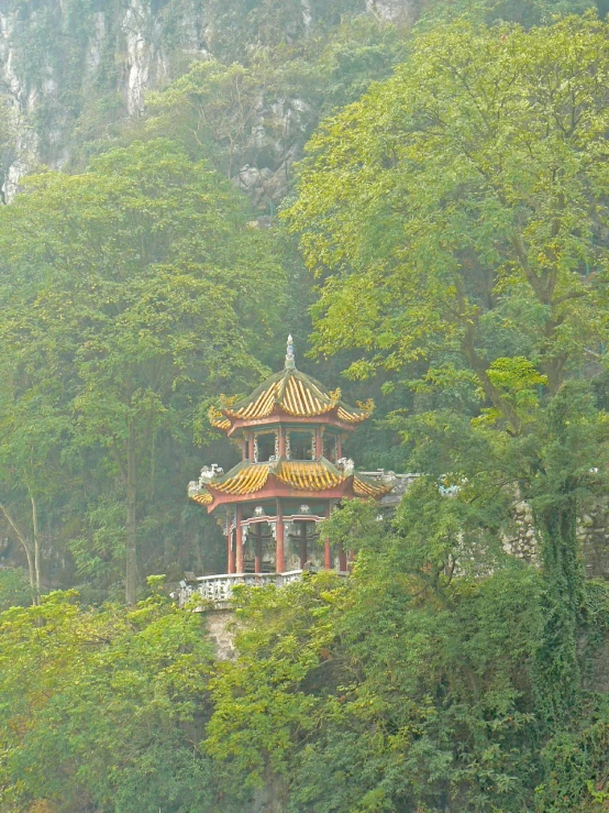 a view of a pavilion with many columns, surrounded by greenery