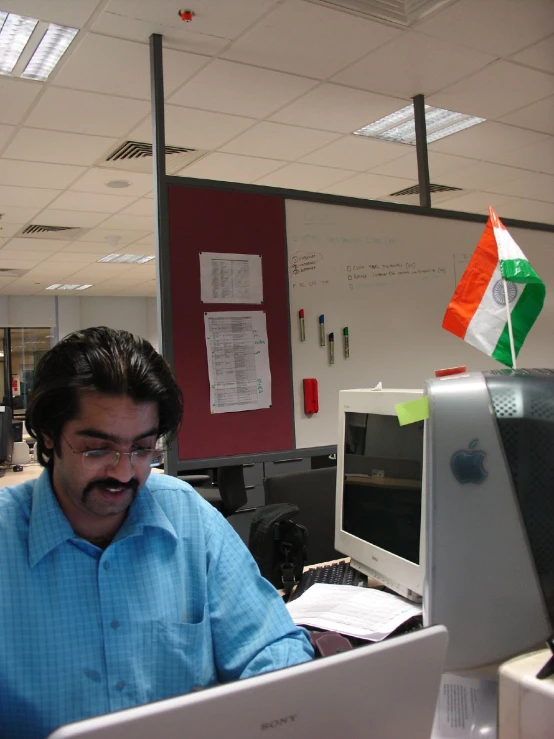 an office worker sitting at his desk working on a computer