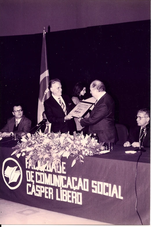 a man holding a document sitting at a table