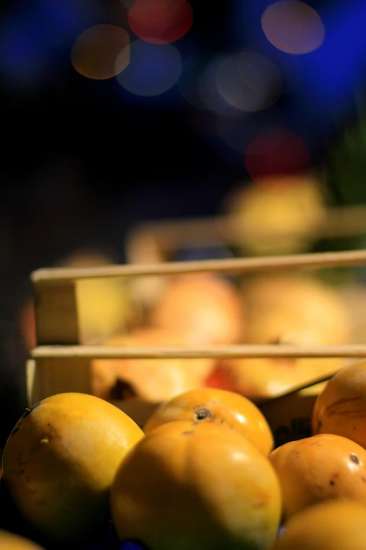 yellow fruits are piled up in boxes on a counter