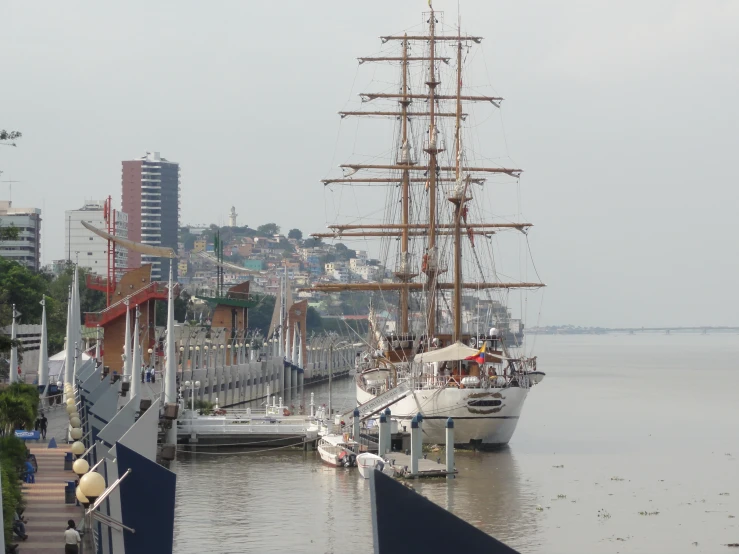 large sailboats docked in water next to city