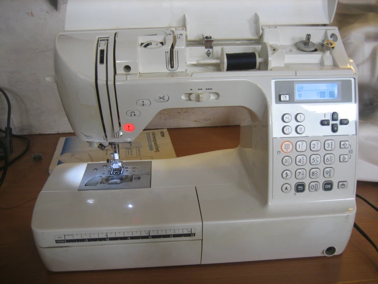 a sewing machine sits on a table next to an alarm clock