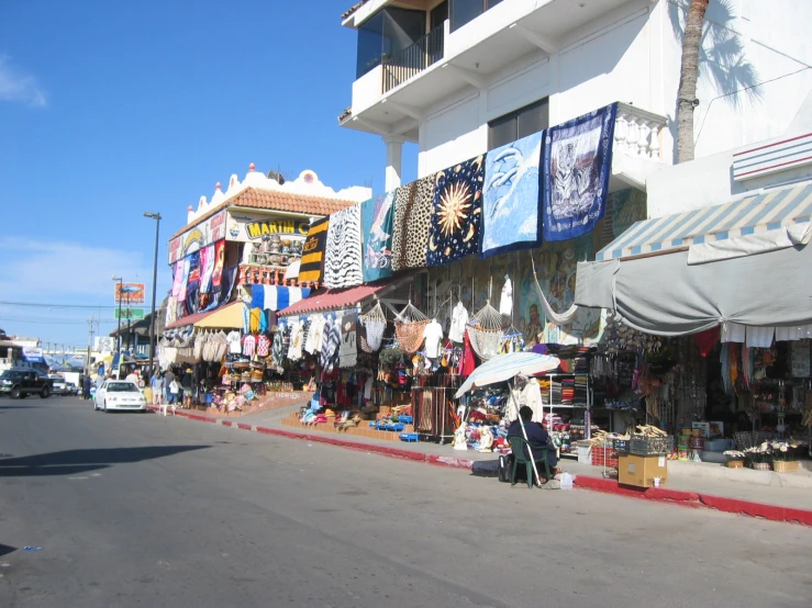 shop fronts with various colored banners line the road
