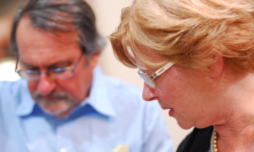 a man and woman are looking at a cell phone