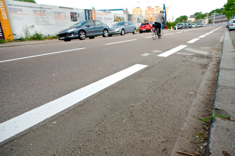 the cyclist is going down the street with his bicycle