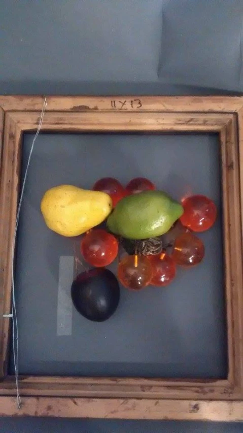 an old wooden frame with a variety of fruits in it