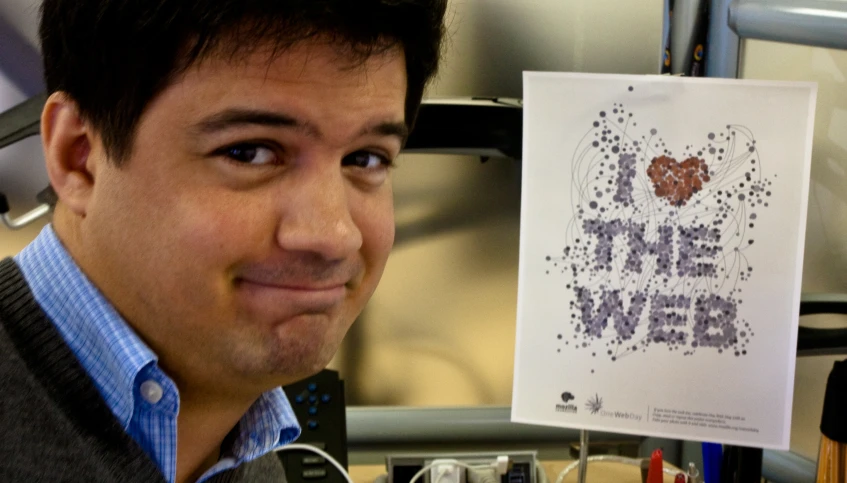 a man holding up a print advertising the web