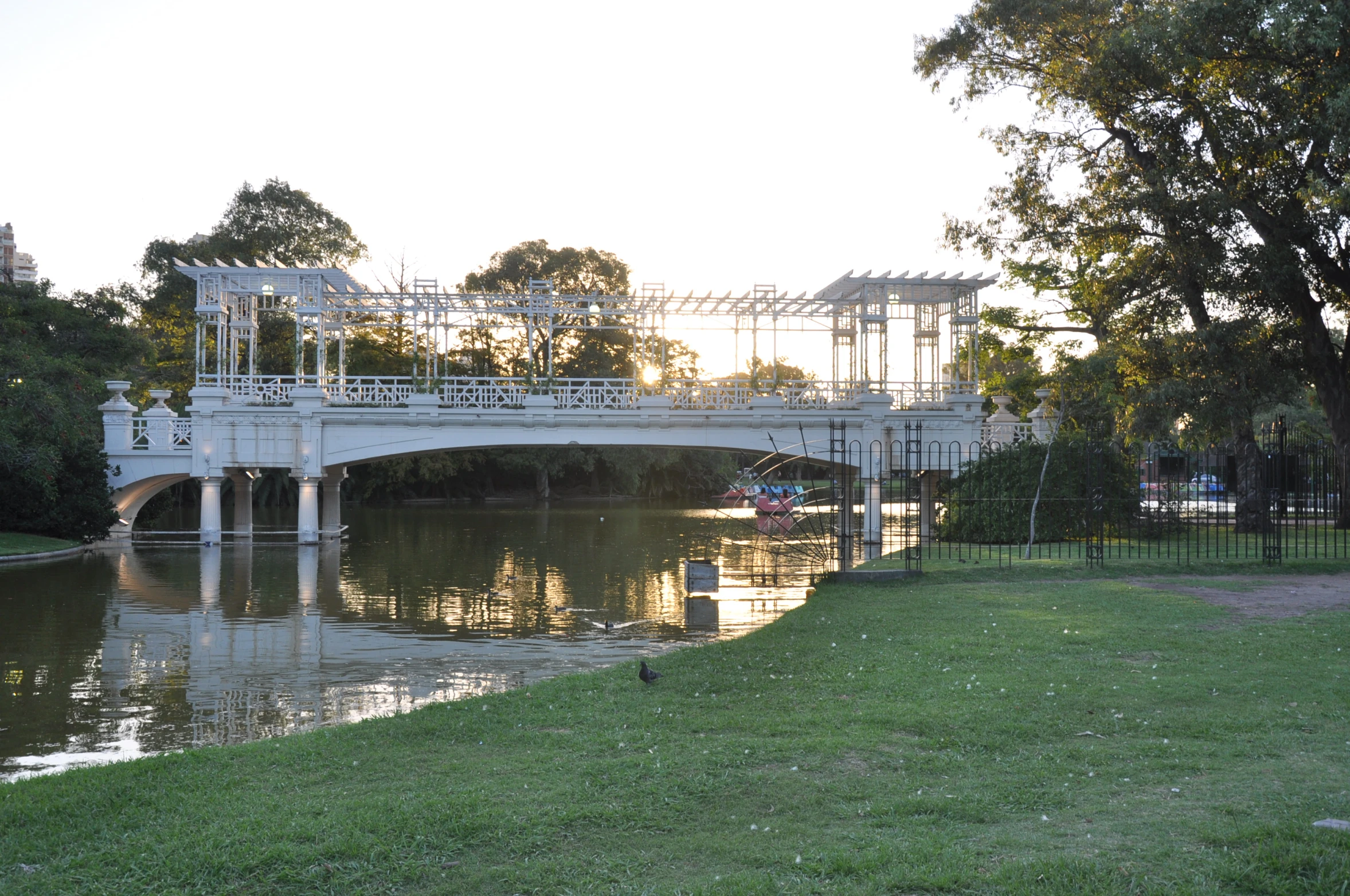 an ornate bridge over a river under a cloudy sky