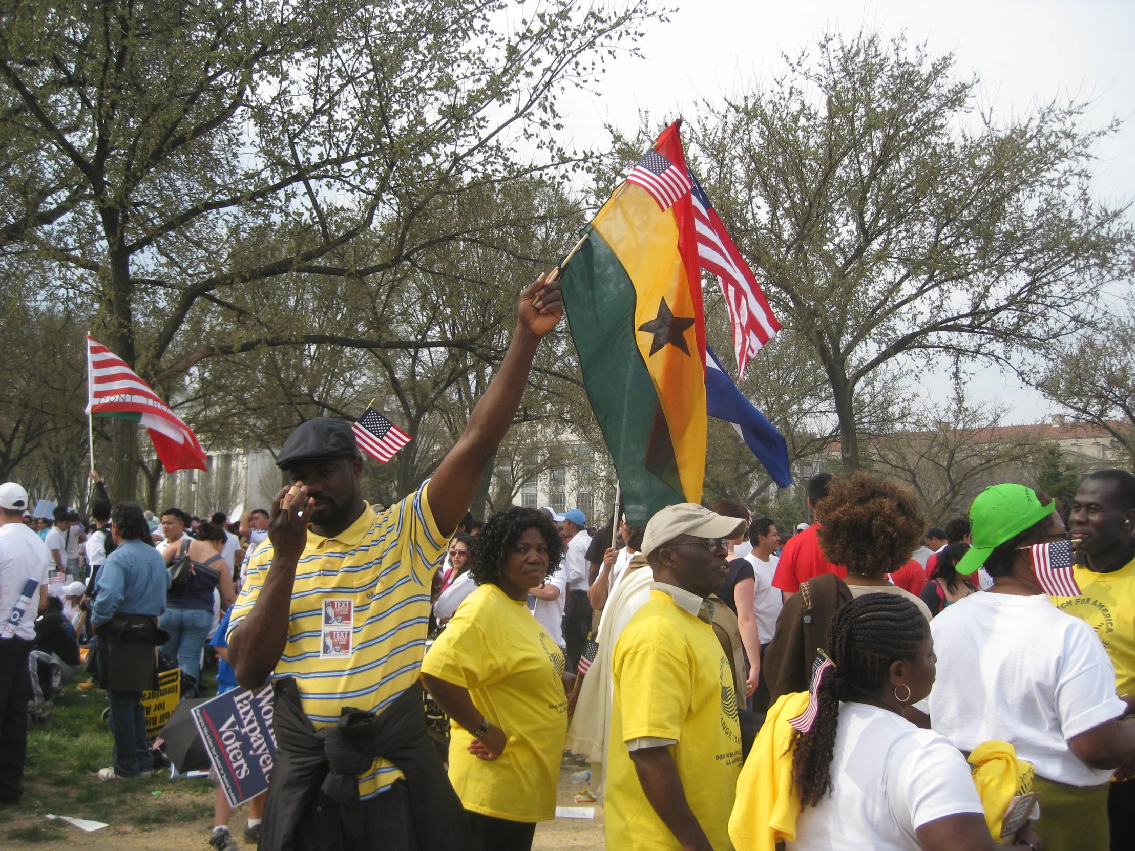 a man standing with his arm up in the air and many people behind him