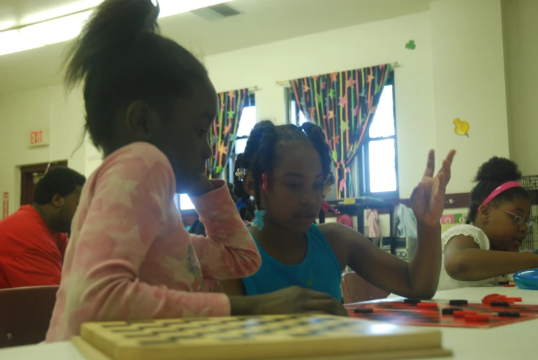 young children playing a board game on a table