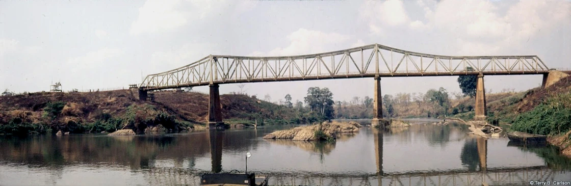 a bridge over the river with a boat underneath