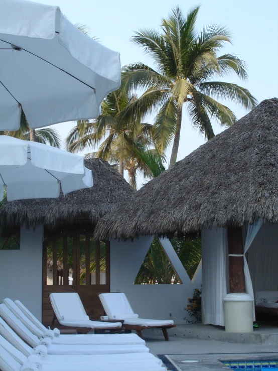 several lounge chairs sit in front of the el swimming pool