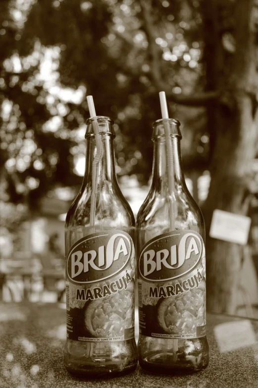 two empty drinks bottles with straws in them