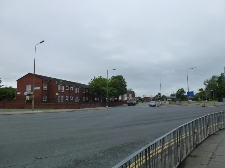 an empty city street with a red brick building on the corner