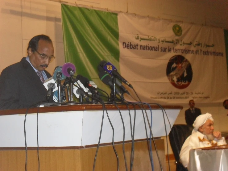 a large crowd of people at a podium with microphones in front of them