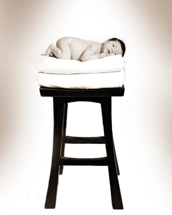 an infant sleeping on top of a stool