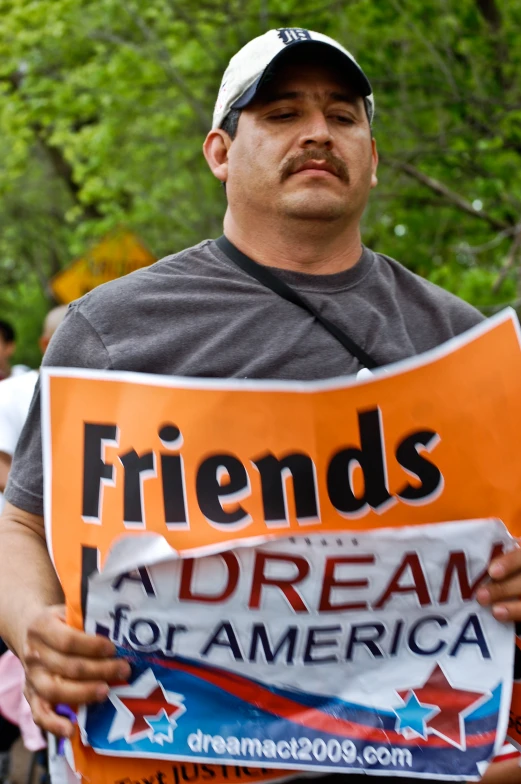 there is a man holding a sign with friends on it