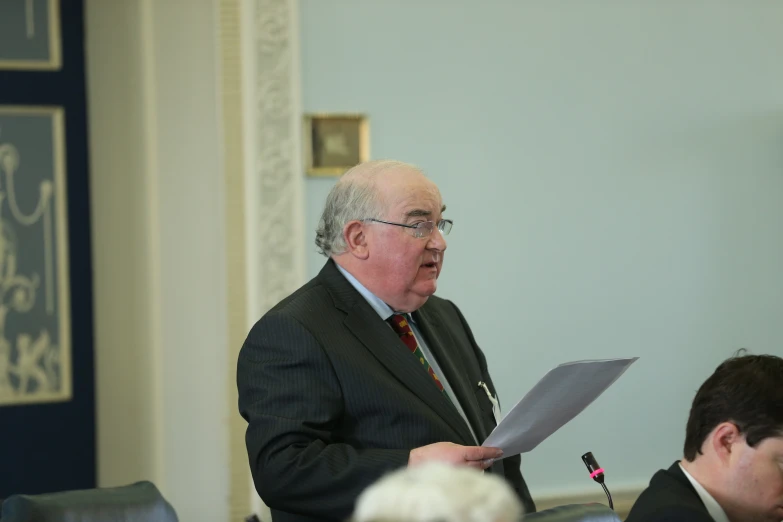 a man in glasses speaks at a table