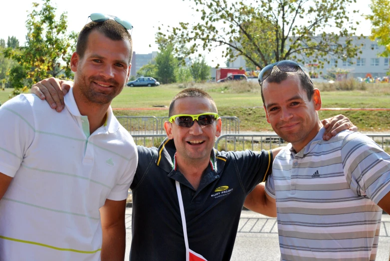 three men standing next to each other posing for a picture