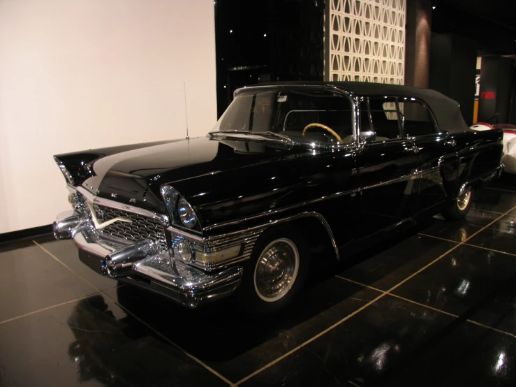 a classic black and white car is parked in a black and white garage