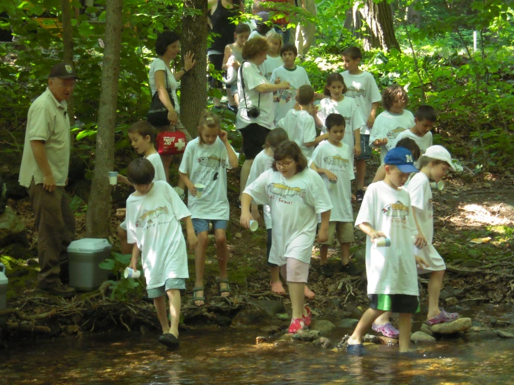 several young people stand next to each other by the water