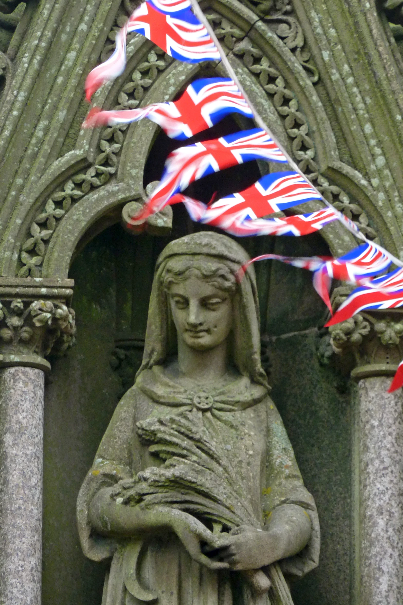 a statue with british flags flying on it