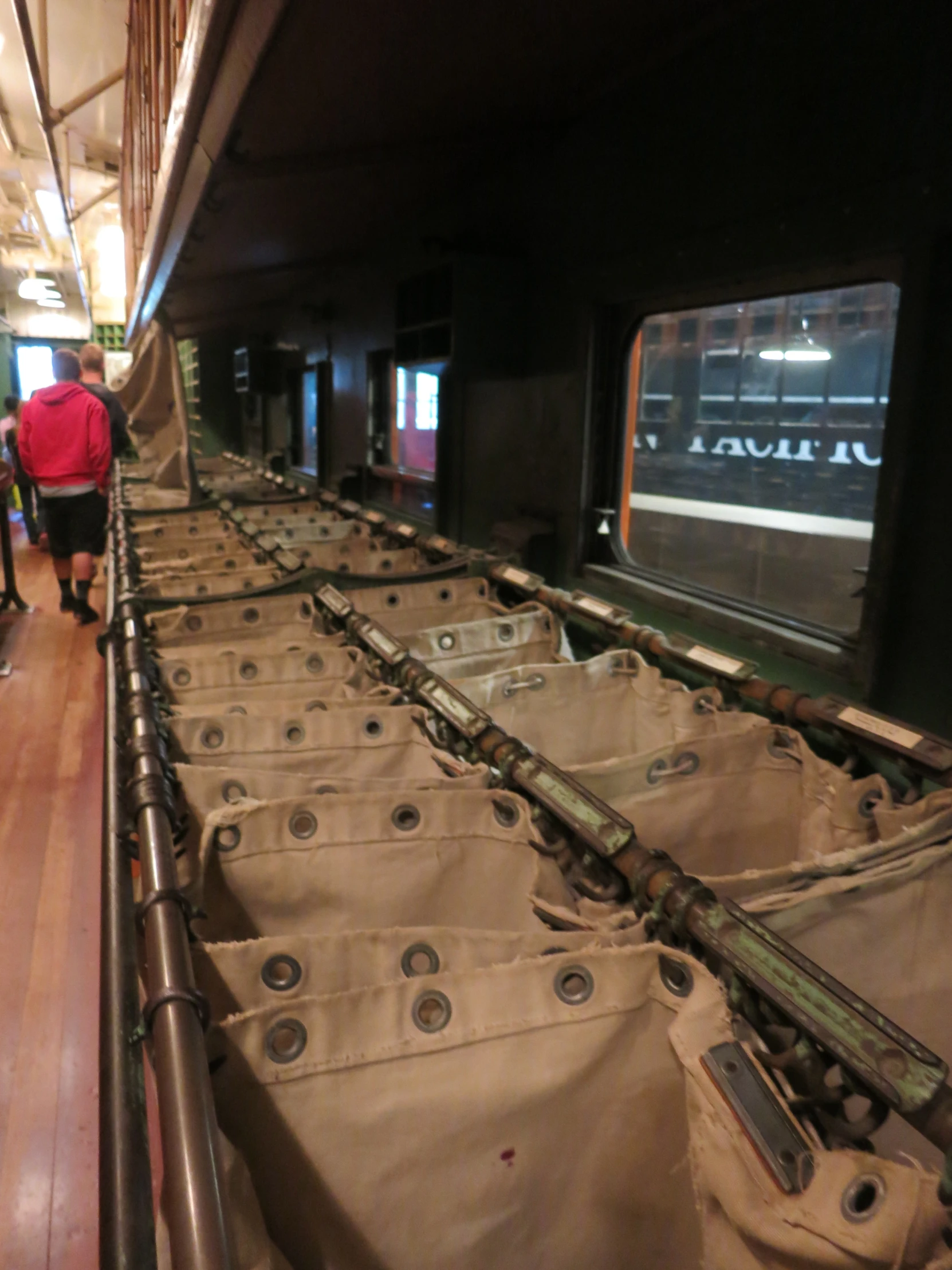 people walking down a long row of train carts