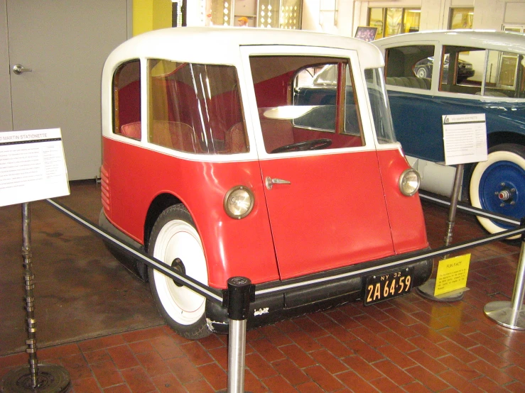 there is a small red and white vehicle on display